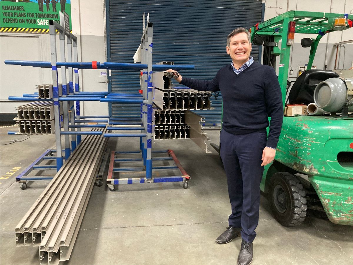Chris Bagatelos, CEO and co-founder of Bagatelos Architectural Glass Systems, showing off aluminum frames that will be part of Aggie Square’s glass curtain walls
