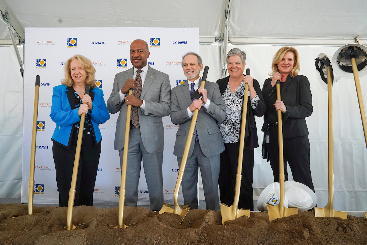 Provost Mary Croughan, Chancellor Gary May, Associate Vice Chancellor Bob Segar, and Vice Chancellor Kelly Ratliff pose with golden shovels at the Aggie Square groundbreaking