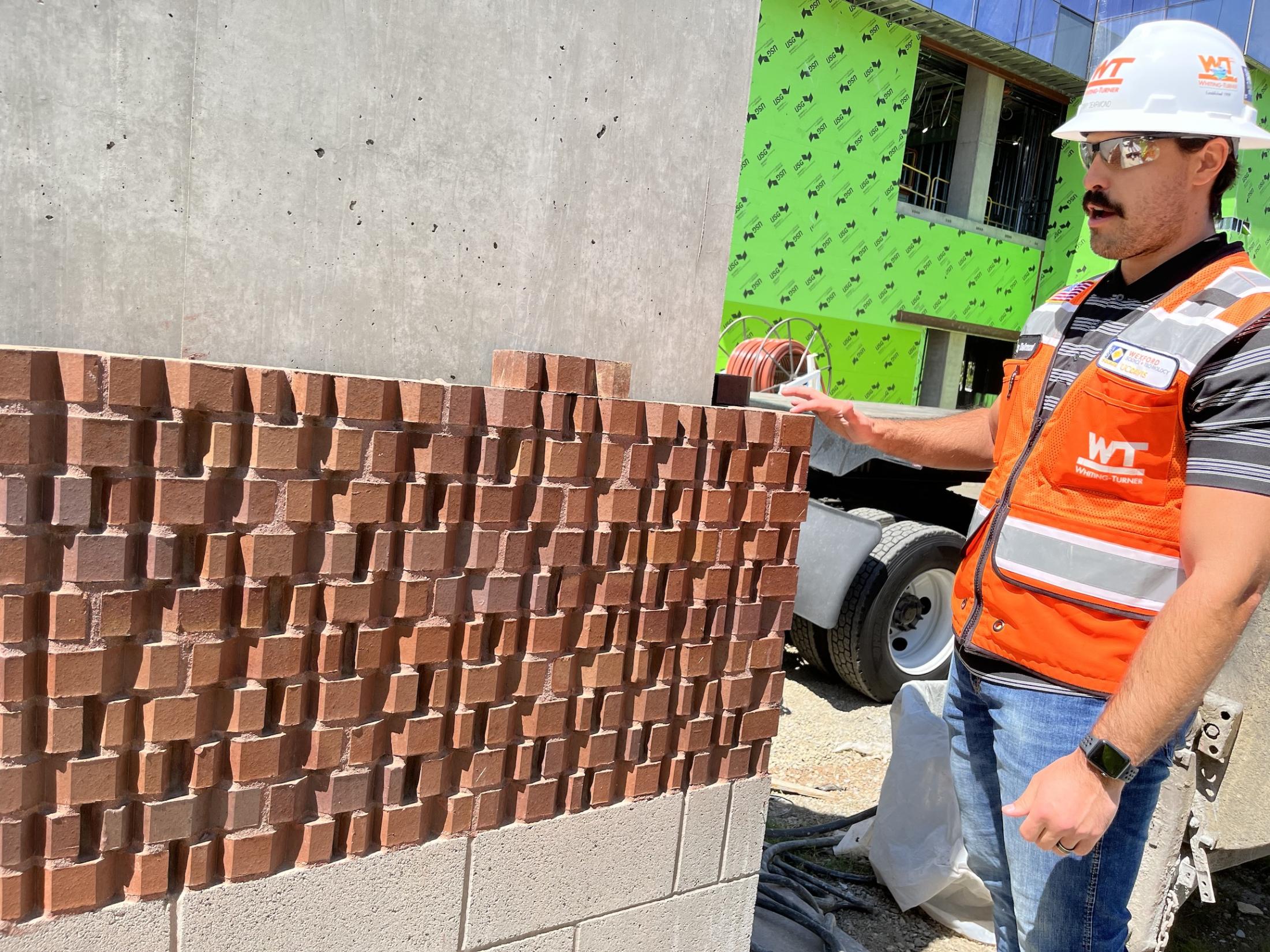 Person stands by a test installation of bricks