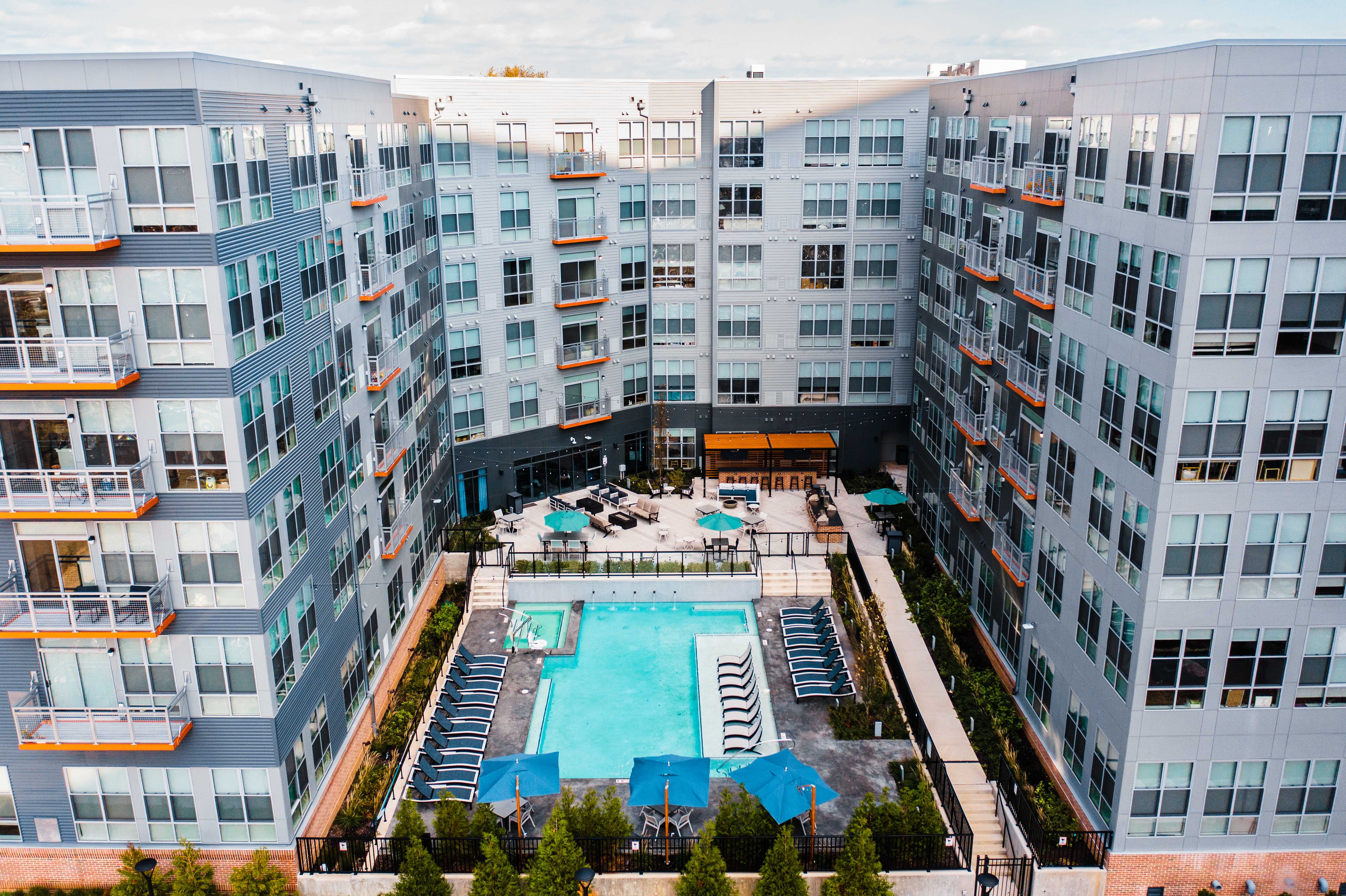 Aerial shot of a U-shaped apartment complex with a pool located between the buildings.