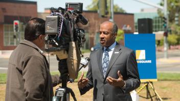 Chancellor May speaks to a television reporter.