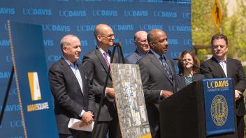 Mayor Darrell Steinberg, Assemblymember Kevin McCarty, Councilmember Jay Schenirer, Chancellor Gary May, Eve Bukowski and Barry Broome gather around a podium at the Aggie Square press conference.