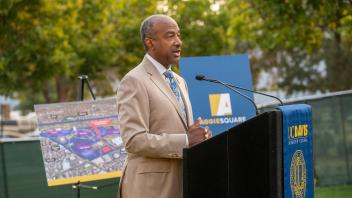 Chancellor May speaks at a podium.