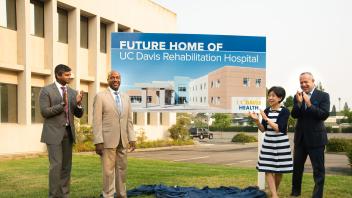 Jason Zachariah, Gary May, Doris Matsui and Darrell Steinberg stand in front of a billboard for the new UC Davis Rehabilitation Hospital.