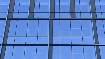 Glass window panes laid in a geometric pattern and reflect the blue sky