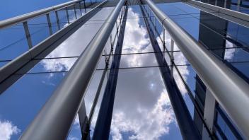 Photo of glass windows on a building, accented with pipes
