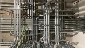 Plumbing pipes arranged in a geometric pattern on a wall