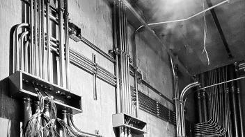 Black and white image of steel pipe management for wires and cables.
