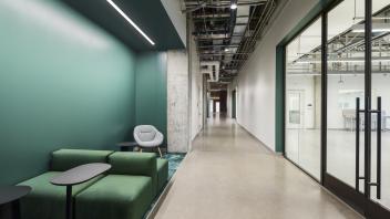 A hallway with a small nook with chairs and tables to the left