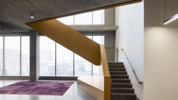 Photo of stairs next to a window, taken from the bottom