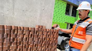 Person stands by a test installation of bricks
