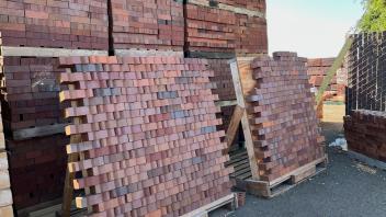 Different patterns of bricks laid out on a propped up pallet
