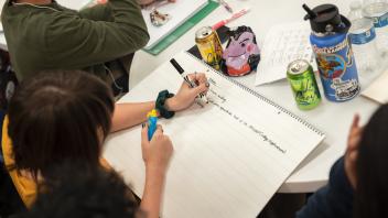 A student writing down notes on ideas