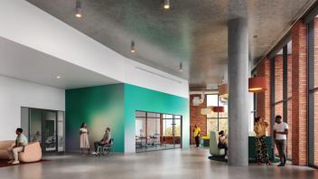 A large hallway with windows on the right and people standing and talking