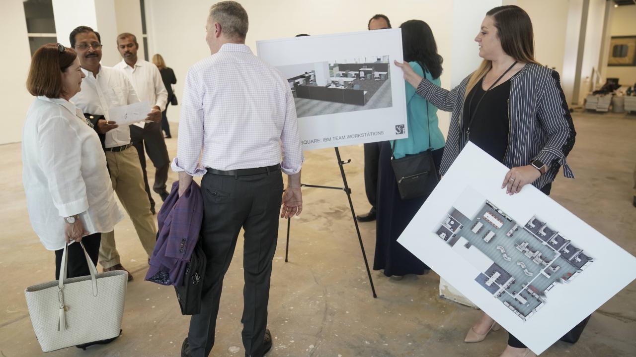 People gather around Aggie Square mockups