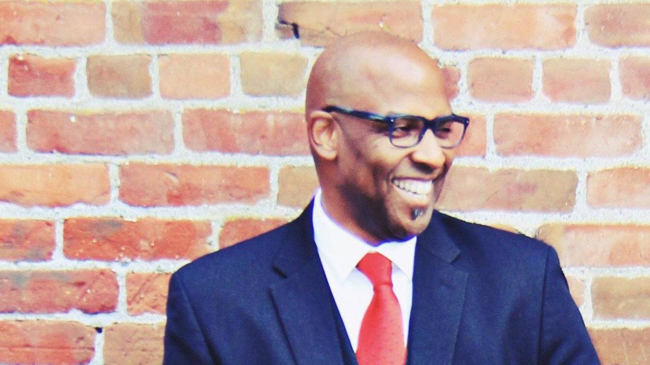 Sacramento Chief Innovation Officer Louis Stewart smiling in front of a brick wall.