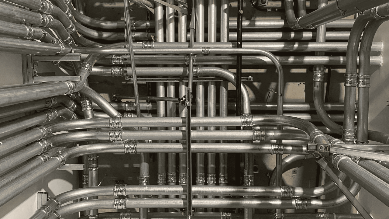 Plumbing pipes arranged in a geometric pattern on a wall