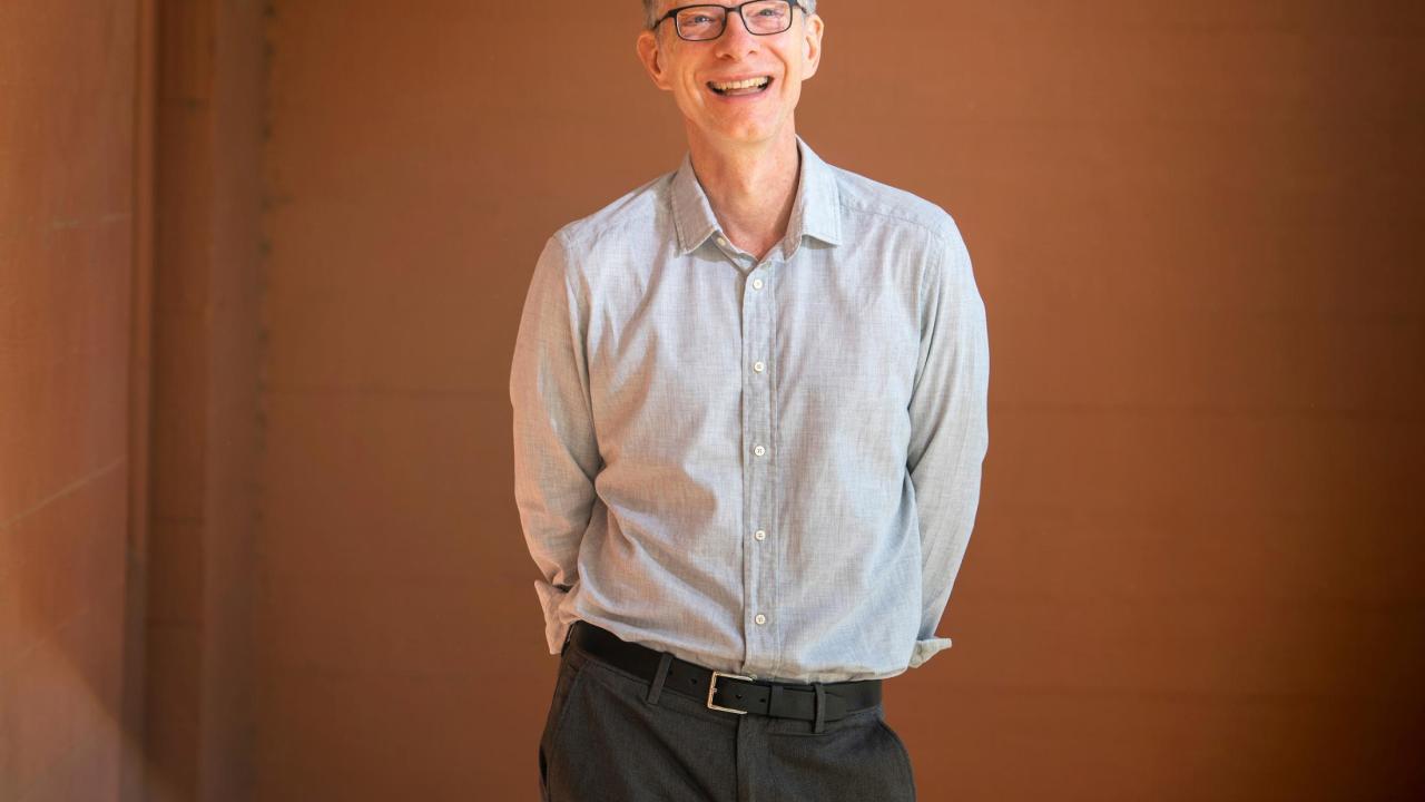 Man standing with hands behind his back.