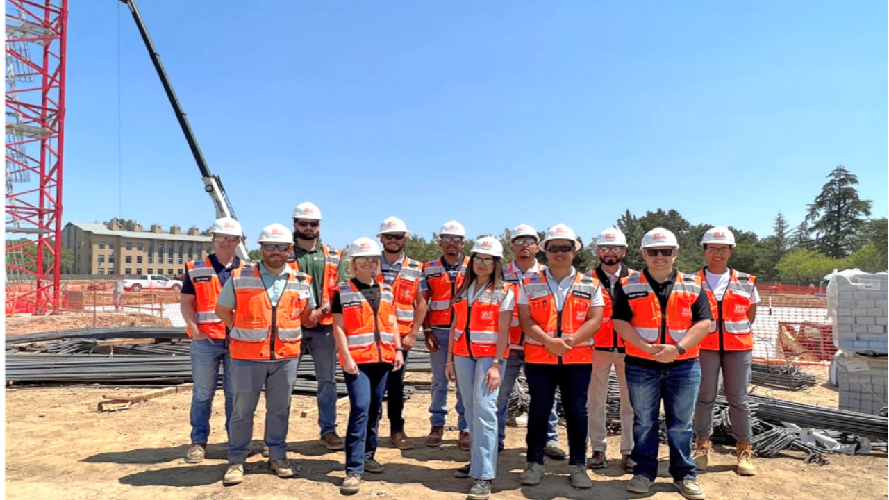 Image of group of Whiting-Turner interns at the Aggie Square construction site wearing vests and hard hats.