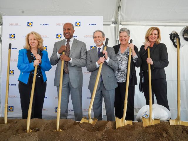 Provost Mary Croughan, Chancellor Gary May, Associate Vice Chancellor Bob Segar, and Vice Chancellor Kelly Ratliff pose with golden shovels at the Aggie Square groundbreaking