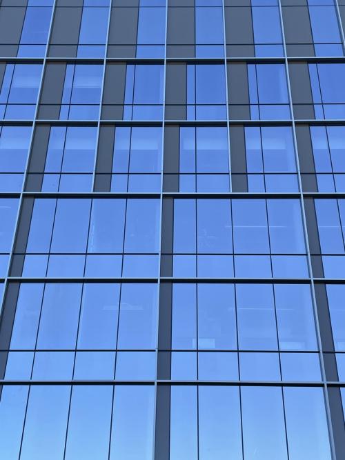Glass window panes laid in a geometric pattern and reflect the blue sky