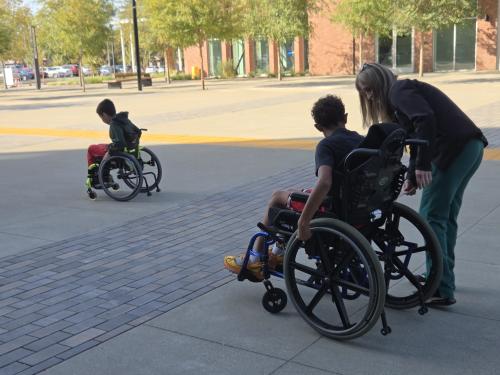Two kids use wheelchairs