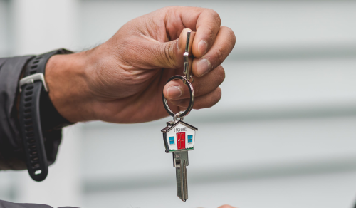 Hand with key to a home