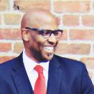 Sacramento Chief Innovation Officer Louis Stewart smiling in front of a brick wall.