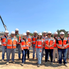 Image of group of Whiting-Turner interns at the Aggie Square construction site wearing vests and hard hats.
